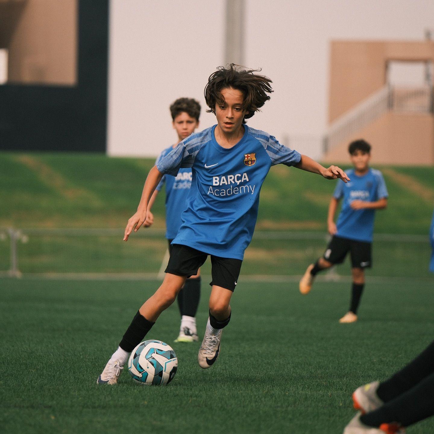 A young EYFL player dribbles the ball upfield